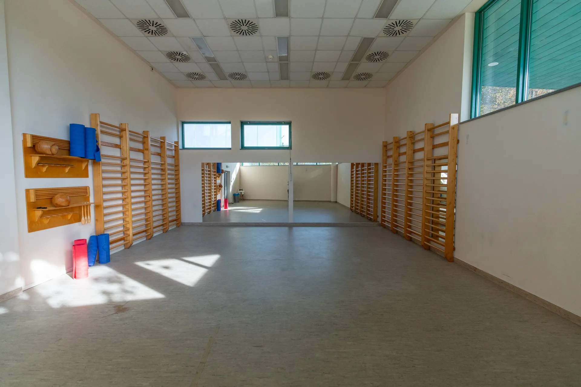 Üres tornaterem bordásfallal és ablakokkal.